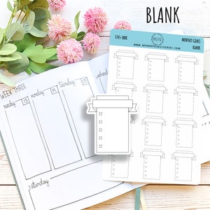 May include: A sheet of blank monthly goal stickers with a banner design. The stickers are white with black outlines and are printed with the text "MONTHLY GOALS BLANK".