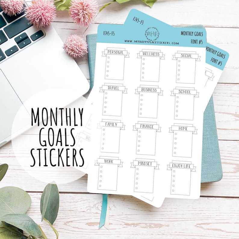 May include: A set of 12 monthly goal stickers with a banner design. Each sticker has a category title, such as "Personal", "Wellness", "Travel", "Business", "School", "Family", "Finance", "Home", "Work", "Mindset", and "Enjoy Life". The stickers are printed on white paper and have a black outline.