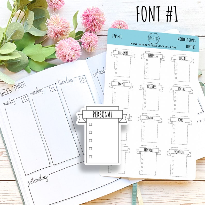 May include: A set of nine monthly goal stickers with a banner design. Each sticker has a different category, such as personal, wellness, social, travel, business, finance, home, mindset, and enjoy life. The stickers are white with black text and lines.
