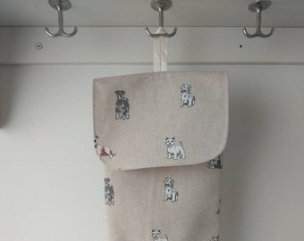 Beige fabric bags storage holder with flap. Bags dispenser. Printed dogs. Kitchen storage.