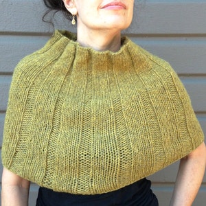 May include: A mustard yellow knitted cowl neck sweater with a ribbed texture.