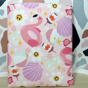May include: Pink fabric pouch with a summer-themed print featuring flamingos, seashells, flowers, and beach balls.