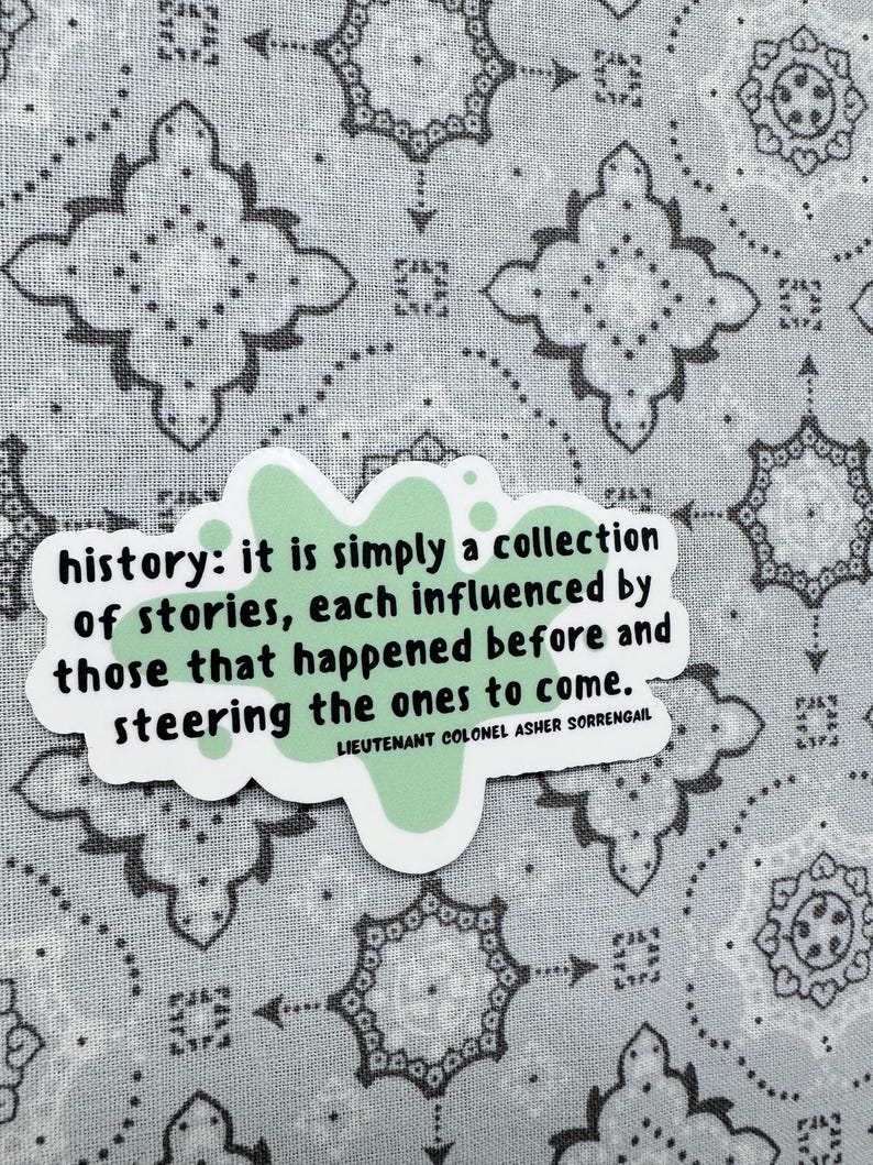 Peut inclure: Un autocollant vert avec un motif de papillon et la citation "history: it is simply a collection of stories, each influenced by those that happened before and steering the ones to come." La citation est attribu&eacute;e au lieutenant-colonel Asher Sorrengail.