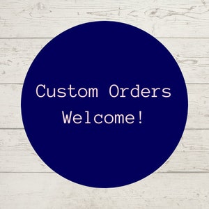 May include: A dark blue circle with white text that says "Custom Orders Welcome!" on a white wood background.