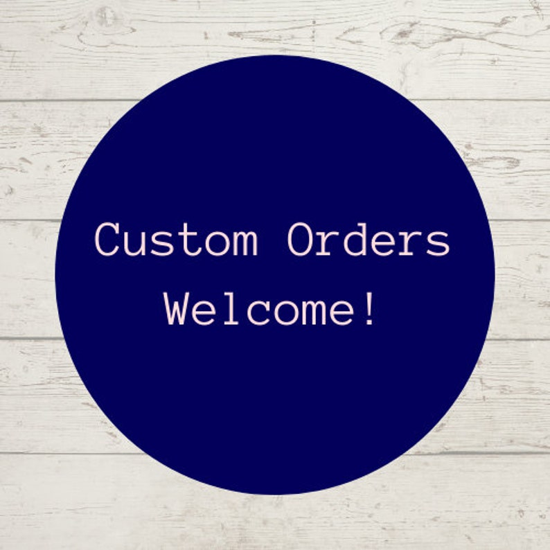 May include: A dark blue circle with white text that says "Custom Orders Welcome!" on a white wood background.
