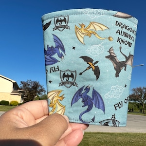 May include: A blue fabric sleeve with a dragon pattern and the text "Dragons Always Know" and "Fly or Die".
