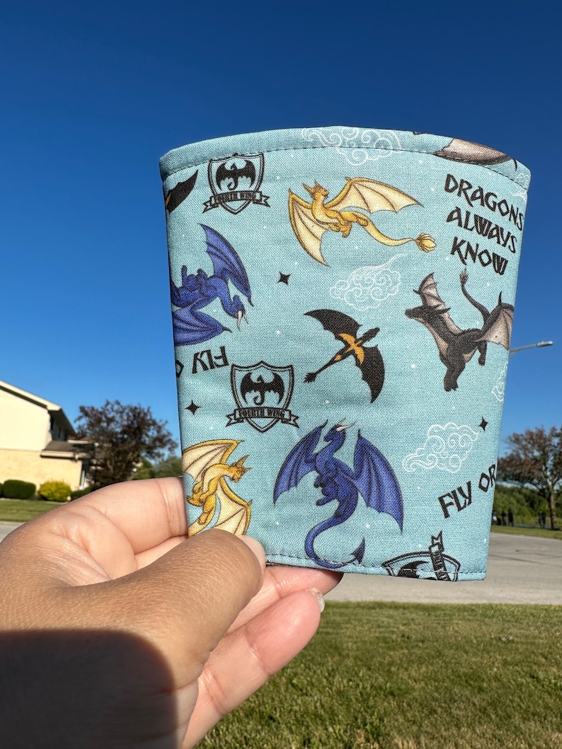 May include: A blue fabric sleeve with a dragon pattern and the text "Dragons Always Know" and "Fly or Die".