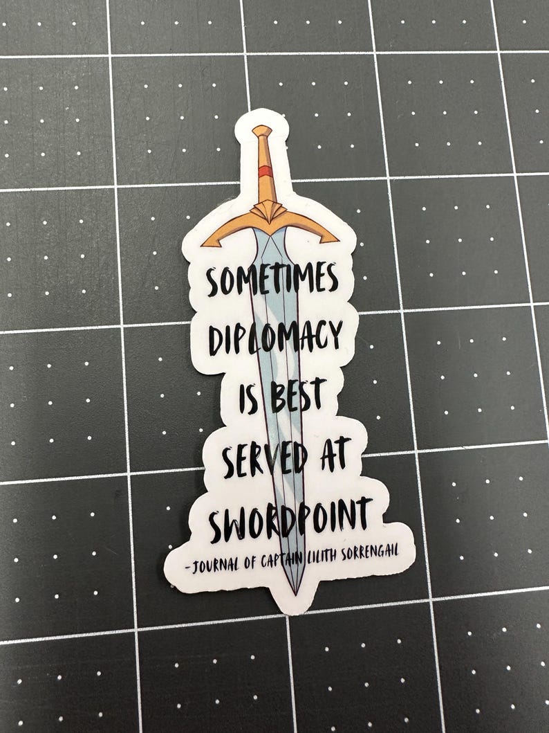 Puede incluir: Una pegatina con un dise&ntilde;o de espada y la cita "Sometimes diplomacy is best served at swordpoint - Journal of Captain Lilith Sorrengail".