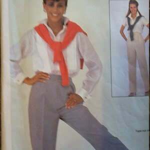 May include: A McCall's Easy sewing pattern for pants. The pattern shows a woman wearing a white shirt with a red sweater tied around her neck and gray pants. The pattern includes instructions for making the pants.