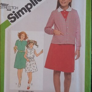 May include: A sewing pattern for a girl's dress and cardigan. The pattern is for sizes 10, 12, and 14. The dress is a red A-line skirt with a white and red striped top. The cardigan is a white and red striped cardigan with a white collar. The pattern is from Simplicity.