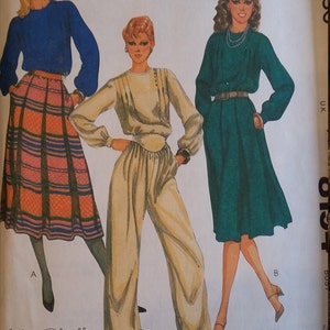 May include: A vintage sewing pattern featuring three women's clothing designs. The first design is a blue top with a plaid skirt. The second design is a cream top with matching pants. The third design is a green dress with a belt. The pattern is by Liz Claiborne and is from a Norton Simon Inc. company.
