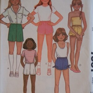 May include: A sewing pattern for girls' shorts. The pattern includes five different styles of shorts, including a pair of green shorts, a pair of pink shorts, a pair of white shorts, a pair of blue shorts, and a pair of yellow shorts. The pattern is from McCall's and is from a Norton Simon Inc. company.