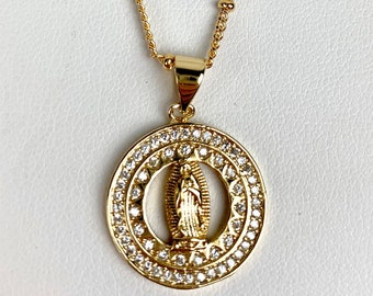 May include: A gold chain necklace with a round pendant featuring a depiction of the Virgin Mary surrounded by clear cubic zirconia stones.