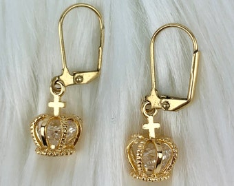 May include: A pair of gold-tone earrings with a clear crystal crown design. Each earring features a small cross charm above the crown.