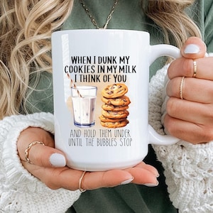 May include: White ceramic mug with a black and brown illustration of a glass of milk and chocolate chip cookies. The text on the mug reads "When I dunk my cookies in my milk I think of you and hold them under until the bubbles stop."