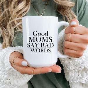 May include: White ceramic coffee mug with black text that reads "Good Moms Say Bad Words".