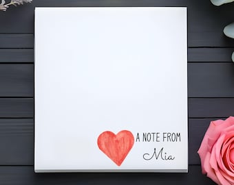 May include: A white card with a red heart and the text "A note from Mia" on a dark wood background with lavender and eucalyptus sprigs and a pink rose.