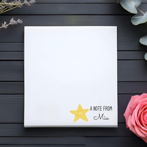 May include: A white notepad with a yellow star and the text "A note from Mia" on a dark wood background with lavender and eucalyptus sprigs.