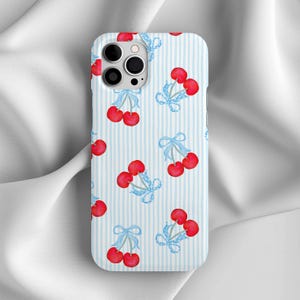 May include: A phone case with a repeating pattern of red cherries tied with light blue bows on a light blue and white striped background. The case has a camera cutout and is designed for a smartphone.