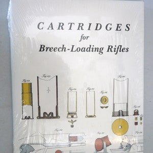 May include: A book titled "CARTRIDGES for Breech-Loading Rifles" by A. Mattenheimer, wrapped in clear plastic. The cover features detailed illustrations of various cartridges and rifle components, including diagrams labeled Fig. 112 through Fig. 139.