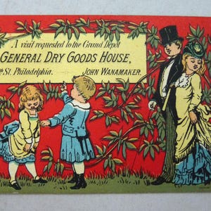 May include: Vintage postcard with a red background and green foliage. The card features an illustration of a family and the text "GENERAL DRY GOODS HOUSE, 15th St. Philadelphia. JOHN WANAMAKER."