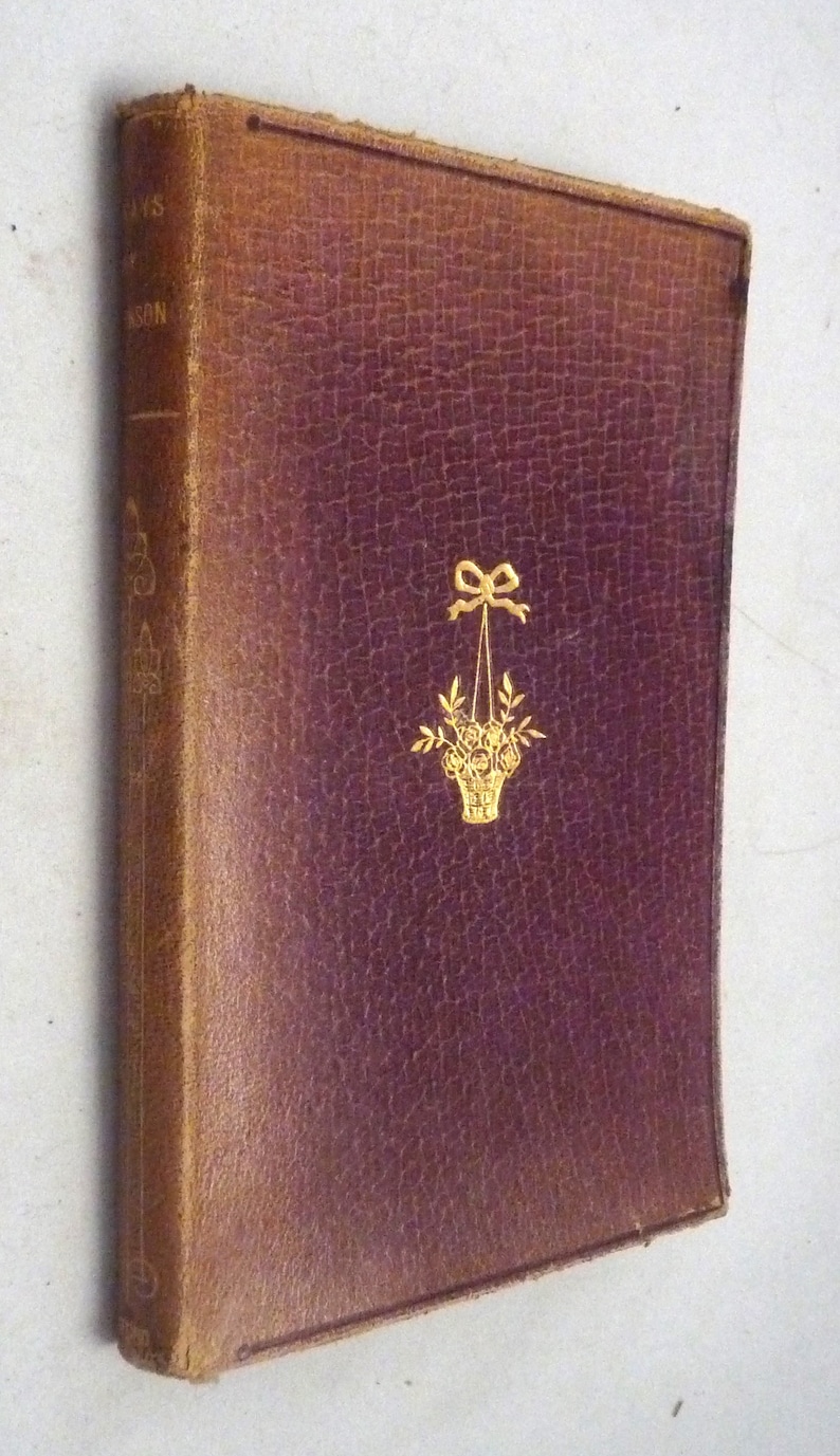 May include: A burgundy leather-bound book with gold lettering and a gold floral design on the front cover. The title of the book is "Days of the Year".