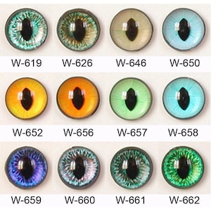 May include: A set of 12 glass eyes for doll making, featuring a variety of colours and patterns, including green, blue, yellow, orange, and purple. The eyes are labelled with their corresponding product codes, such as W-619, W-626, W-646, W-650, W-652, W-656, W-657, W-658, W-659, W-660, W-661, and W-662.