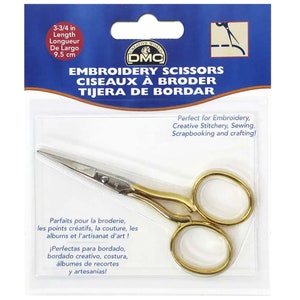 May include: Gold embroidery scissors with a 9.5 cm length. The packaging says "Embroidery Scissors, Ciseaux à Broder, Tijera de Bordar".