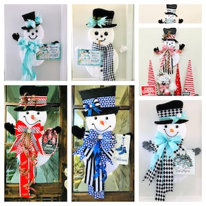 May include: A collection of six snowman door decorations. Each snowman is made of felt and has a different color scheme and design. The snowmen are holding signs that say "Snow Place Like Home", "Welcome", and "Gather 'round the Snowmen".