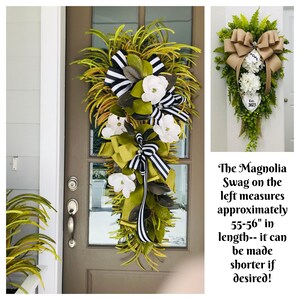 May include: Two magnolia wreaths, one with black and white ribbon and the other with burlap ribbon. Both wreaths are decorated with magnolia leaves and white flowers. The wreath on the left measures approximately 55-56 inches in length. "Est. 2023" is written on the wreath on the right.