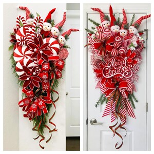May include: A red and white Christmas door swag with candy canes, a red bow, and a sign that says "Merry Christmas".