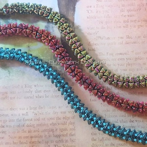 May include: Four beaded bracelets in shades of teal, red, and green. Each bracelet features a repeating pattern of triangular beads and small round beads. The bracelets are displayed on a vintage book page.