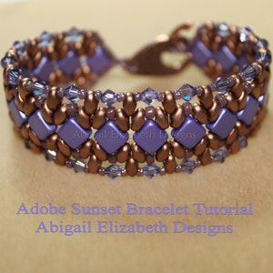 May include: A handcrafted bracelet with a copper clasp and beads. The design incorporates lavender square beads and copper-toned teardrop beads. Tiny, clear crystals are woven into the pattern. The text "Adobe Sunset Bracelet Tutorial Abigail Elizabeth Designs" is visible.