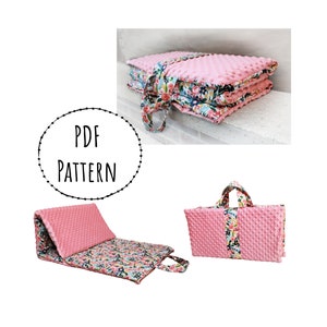 Puede incluir: Una alfombra de juego rosa y floral se pliega en un tamaño compacto para facilitar su almacenamiento y transporte. La alfombra tiene una superficie suave y acolchada y un asa para llevarla. PATRÓN PDF.