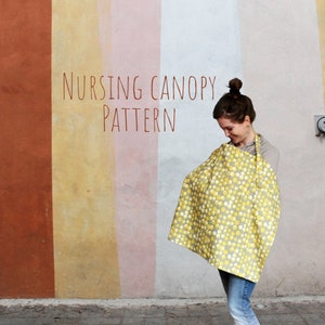 May include: A woman wearing a yellow and white polka dot nursing cover with the text "Nursing Canopy Pattern" on a colorful wall.