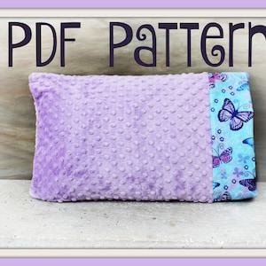 May include: PDF Pattern for a lavender and blue butterfly patterned pillow. The pillow is made with a soft, textured fabric.