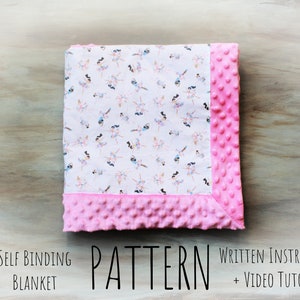 May include: A pink and white self-binding blanket with a pattern of fairies. The blanket is made with a soft, plush fabric and has a pink dot pattern on the border. The text "SELF BINDING BLANKET PATTERN WRITTEN INSTRUCTION + VIDEO TUTORIAL" is printed below the blanket.