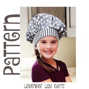 Puede incluir: Una niña lleva un gorro de chef gris con lunares blancos y una banda a rayas. Lleva una camiseta morada oscura. La palabra "Pattern" está impresa verticalmente a la izquierda. El texto "Lavender Lily Gifts" está impreso en la parte inferior.