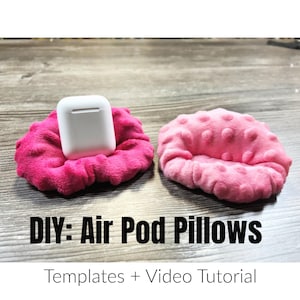 May include: DIY Air Pod Pillows: Two pink fabric pillows, one with a white AirPod case on top, with the text "DIY: Air Pod Pillows" and "Templates + Video Tutorial" below.