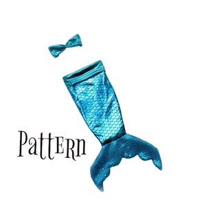 May include: A turquoise mermaid tail costume with a matching bow. The tail is made of a sparkly fabric and has a fin at the bottom. The bow is attached to the top of the tail.