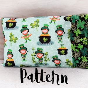 May include: A green and black pillow with a pattern of leprechauns, pots of gold, and shamrocks. The pillow has a black and green shamrock pattern on the back.