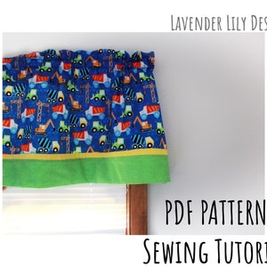 May include: A blue and green fabric valance with a construction vehicle print. The valance has a yellow trim and a green bottom border. The text "LAVENDER LILY DESIGN" is in the top right corner of the image. The text "PDF PATTERN SEWING TUTORIAL" is in the bottom right corner of the image.