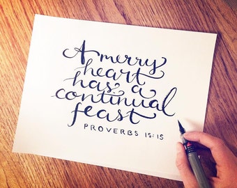 A Merry Heart has a Continual Feast Scripture wall hanging, Proverbs 15:15 calligraphy Bible verse wall art