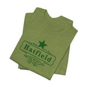 May include: A green t-shirt with a green logo that says "Rain 4 LA Hatfield" with a star above the text.