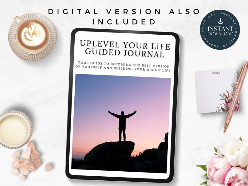 May include: A digital download of a guided journal titled "Uplevel Your Life Guided Journal". The cover features a silhouette of a person with arms outstretched standing on a rock against a pink and purple sunset sky. The text "Your guide to becoming the best version of yourself and building your dream life" is below the title.