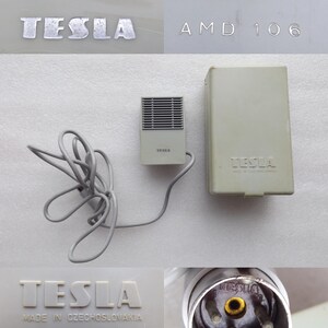 May include: A collection of vintage Tesla electronic components. Includes a small, rectangular speaker with a grill, a box, and a plug. The Tesla logo is visible on several items, with text indicating manufacture in Czechoslovakia.