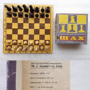 May include: A vintage chess set with a wooden chessboard and pieces. The board is brown and yellow, with black and white chess pieces. A box with chess piece icons and the word "ШАХ" is also present. The set is likely from the 1980s.