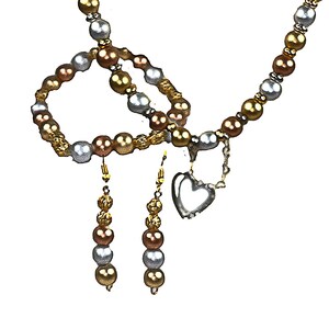 May include: A jewelry set consisting of a necklace and matching drop earrings. The necklace features a repeating pattern of metallic gold, bronze, and silver beads with a silver-toned heart charm. The earrings mirror this bead color scheme.