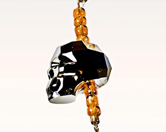 a gleaming gold chain holding a brilliant faceted silver crystal skull charm - 2373H