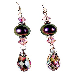 May include: A pair of drop earrings featuring a metallic dark green oval bead, accented by small light pink faceted crystals and a larger faceted teardrop-shaped crystal at the base. The components are connected by silver-toned metal findings.
